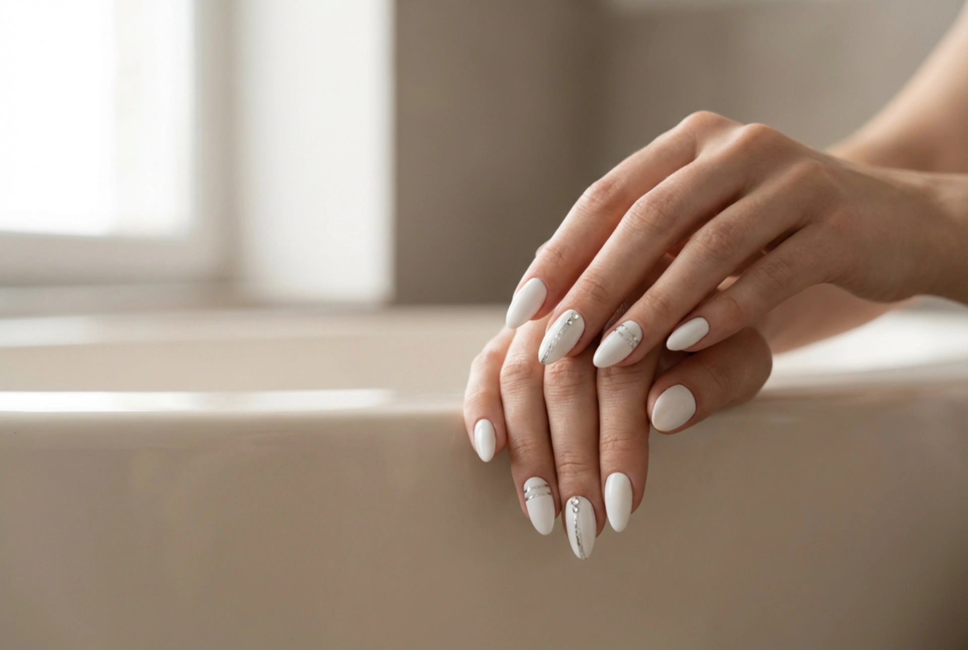 Ongles blancs avec un accent argenté : rubans, feuilles et strass étape par étape